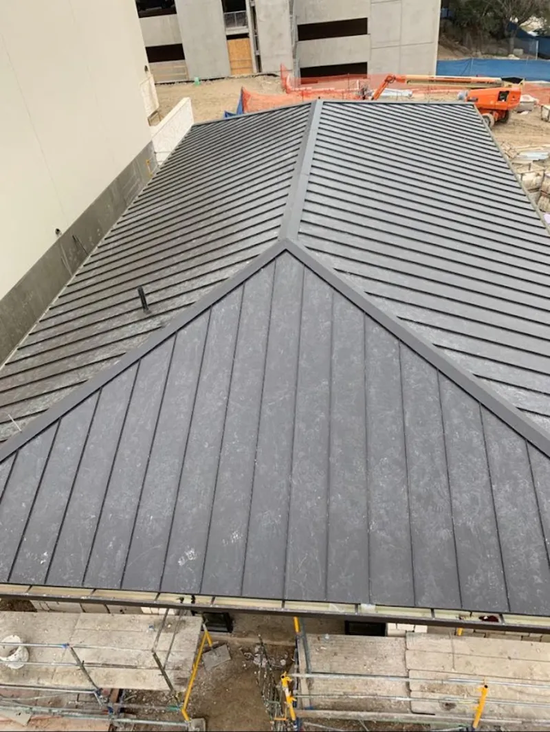 Commercial metal roof construction with crane equipment in Warrenton